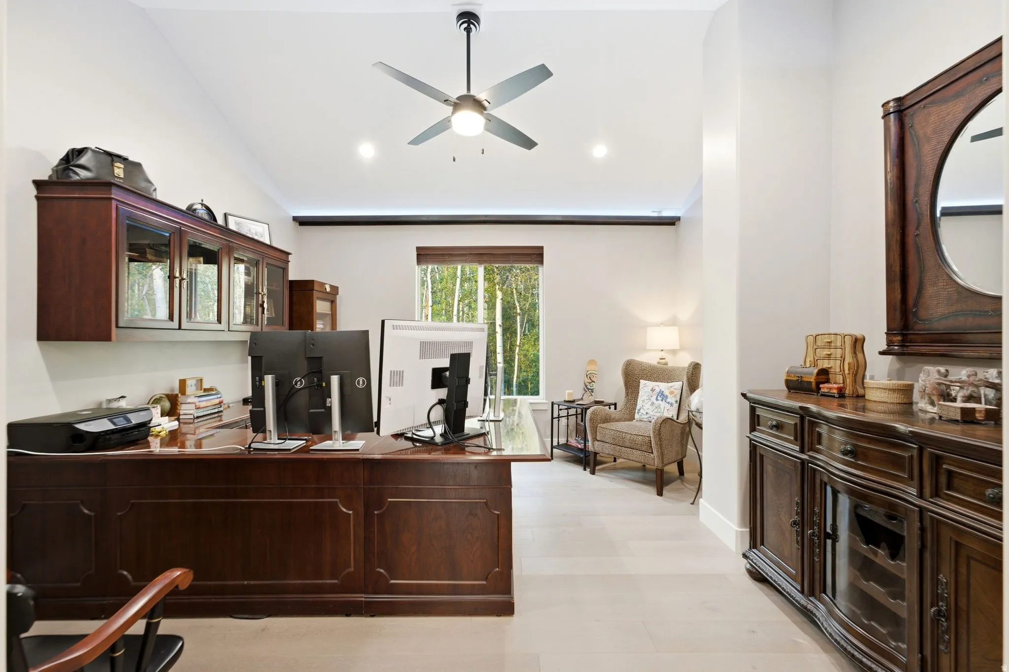 Vaulted ceiling with recessed lighting, wood-finish flooring, a contemporary ceiling fan, and a large window