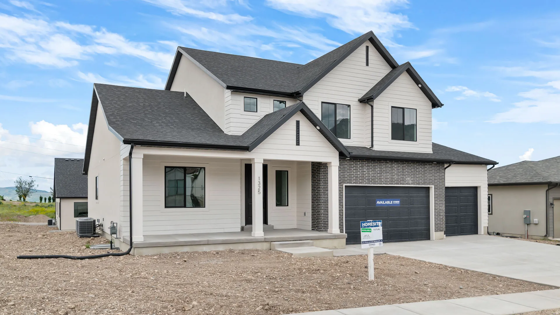 Modern two-story residence featuring a white siding exterior with dark grey brick accents