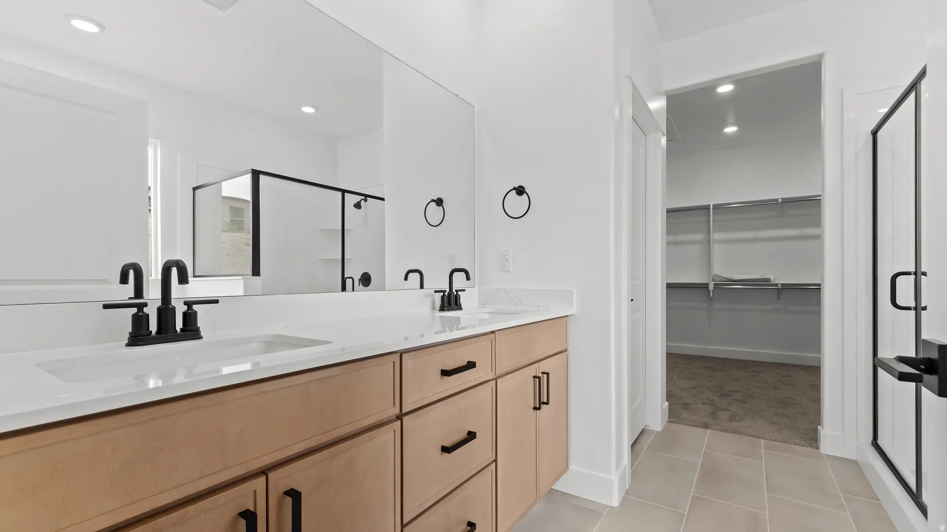 Double vanity featuring dual undermount sinks with matte black fixtures and quartz countertops