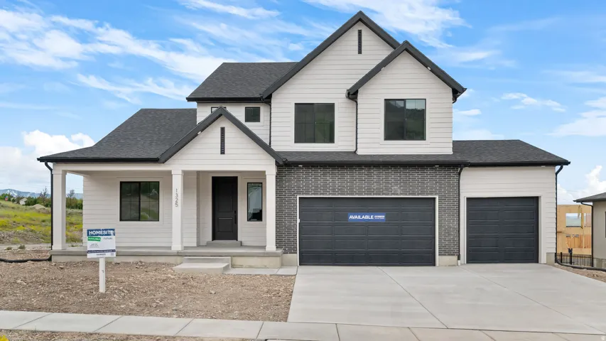 Contemporary two-story residence featuring a combination of white horizontal siding and gray brick facade