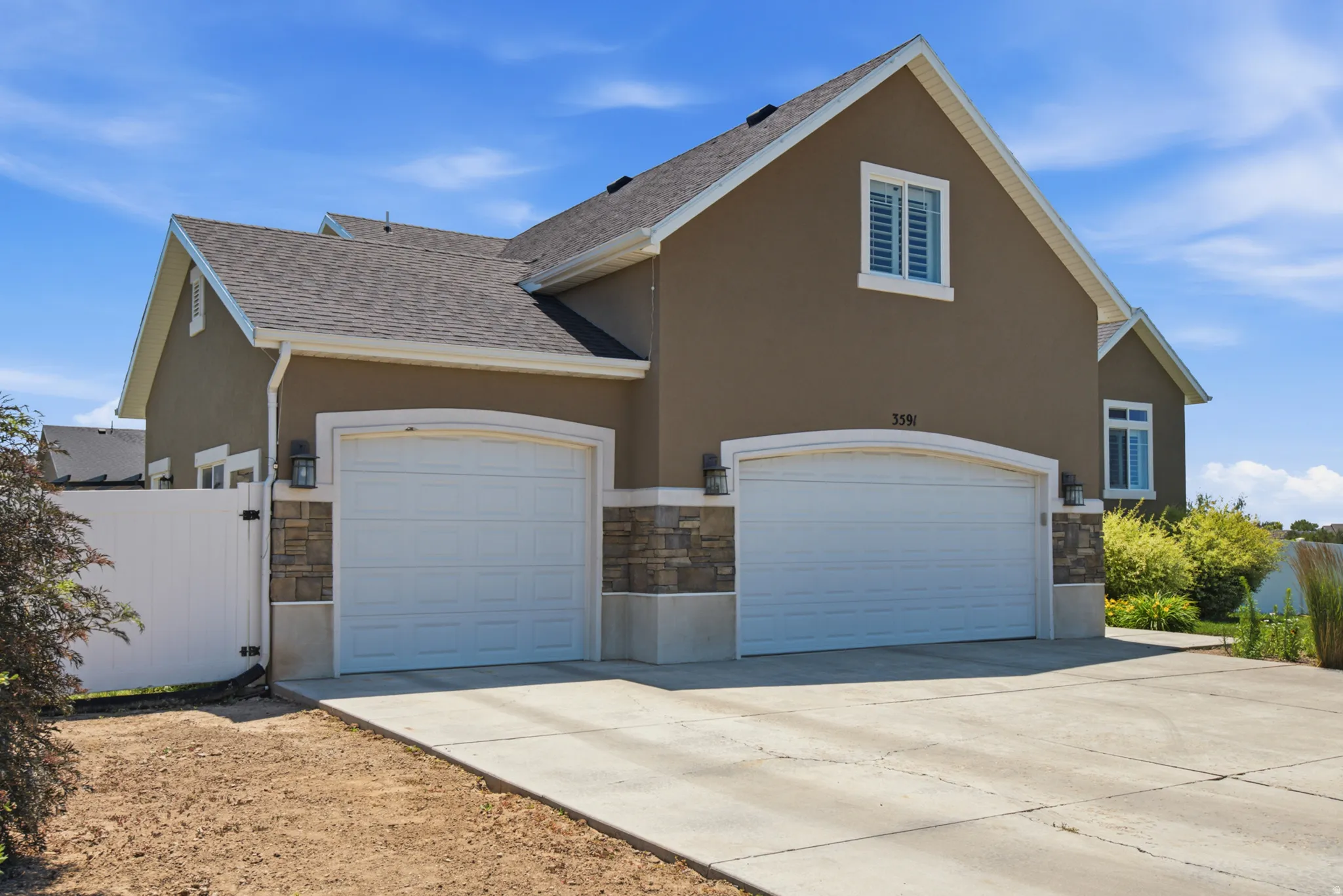 Two-car garage with arched entries and stone veneer accents