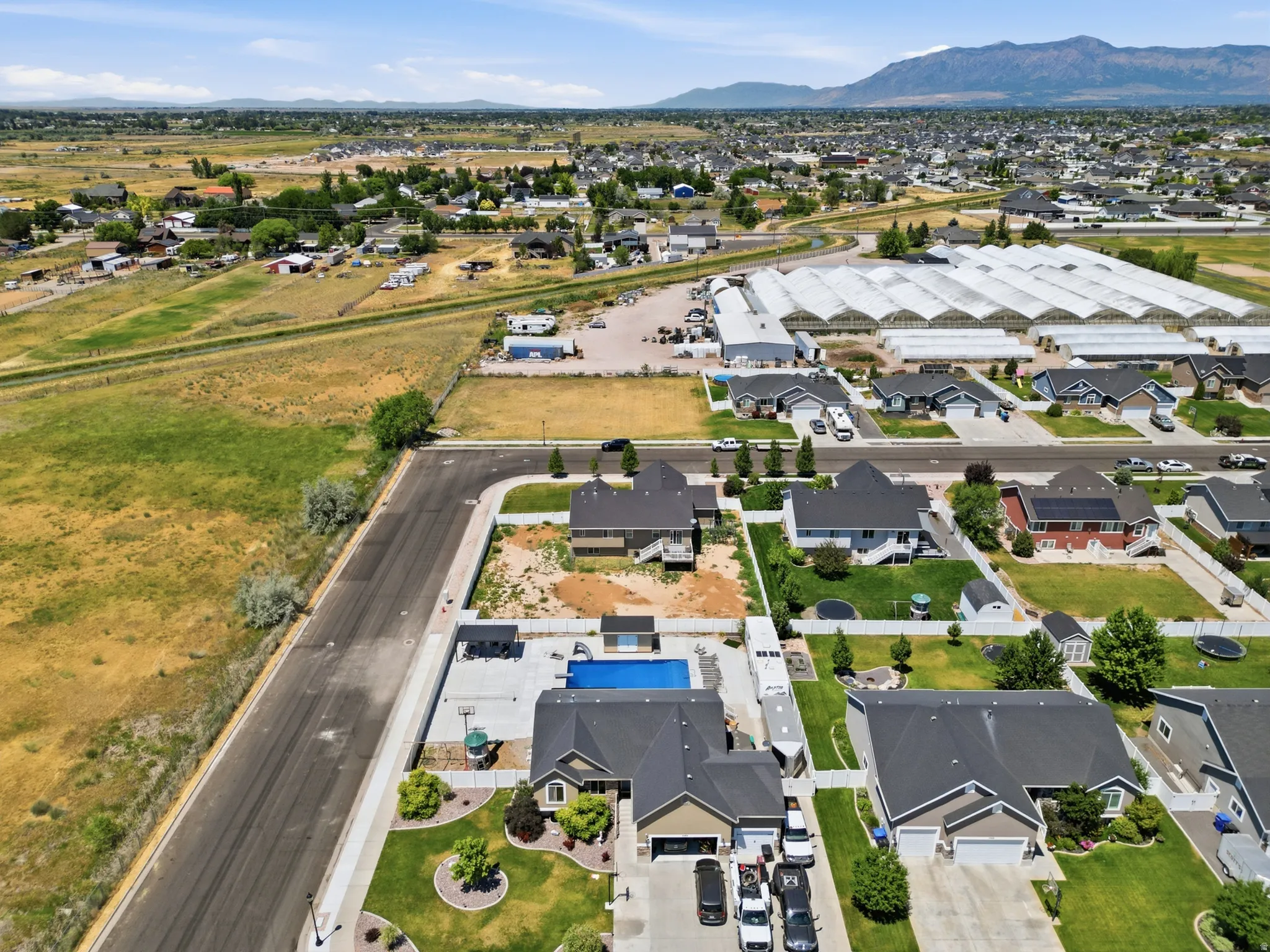 Expansive residential area featuring single-story homes with dark shingle roofs, paved driveways, and landscaped front yards