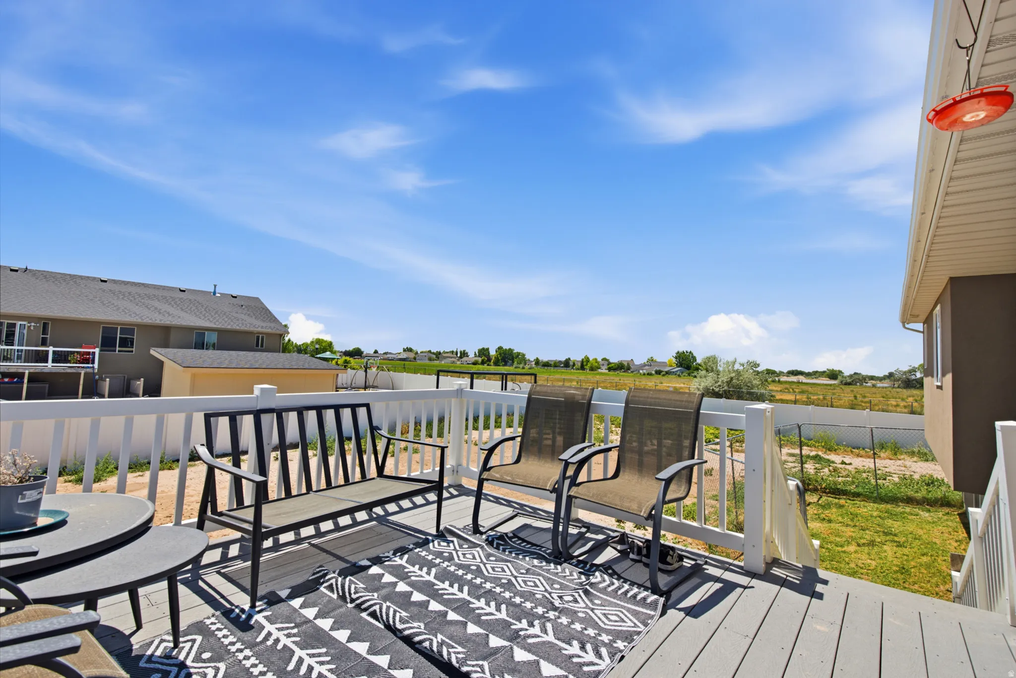 Spacious elevated deck featuring gray composite decking, white railing, and a clear expanse of undeveloped land