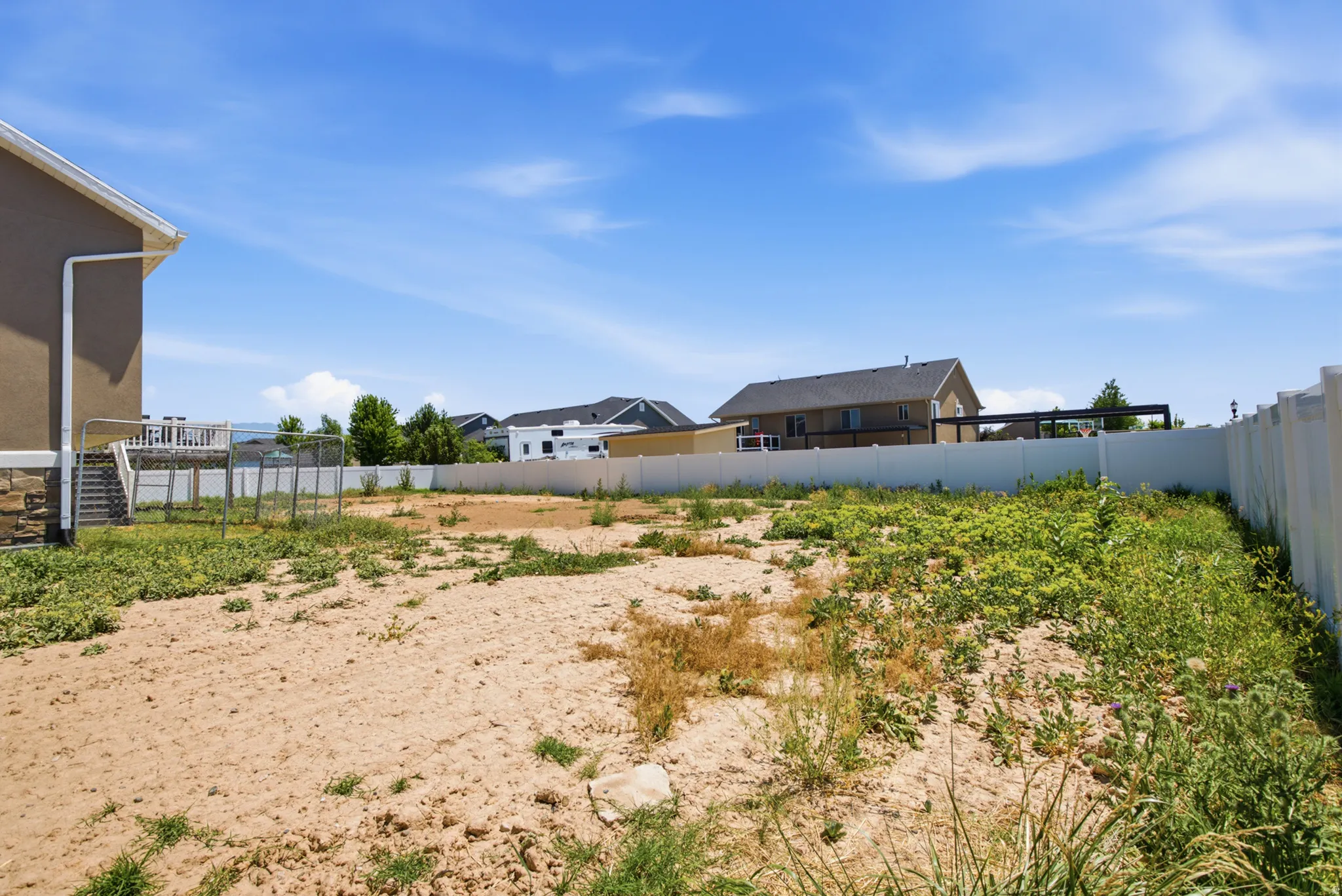 Spacious rear yard with a white privacy fence