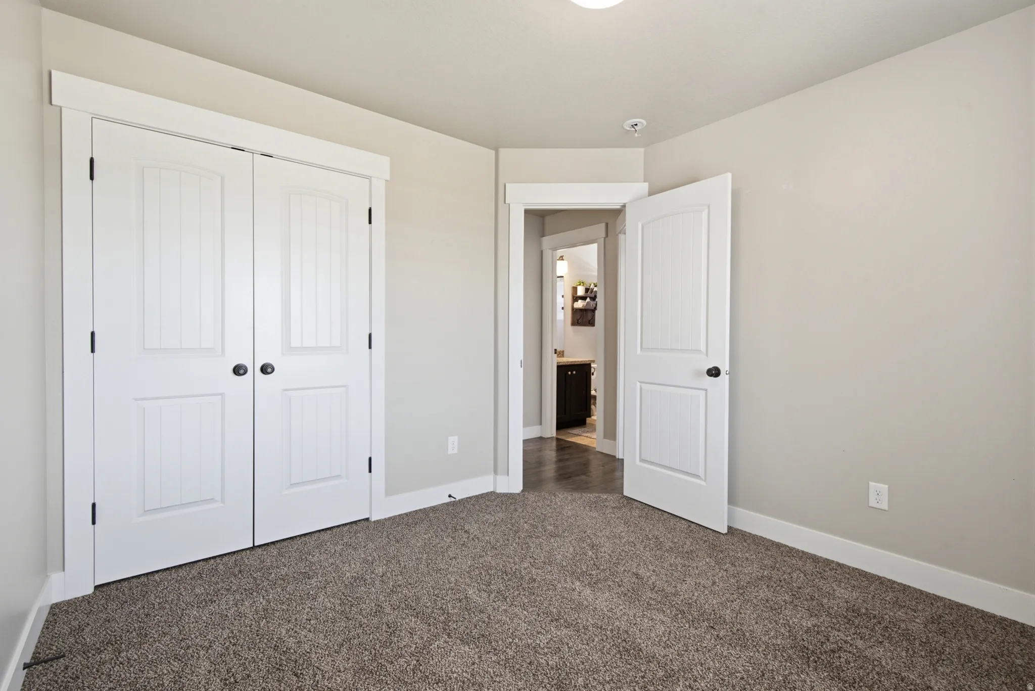 Neutral wall paint in a spacious room featuring textured carpeting