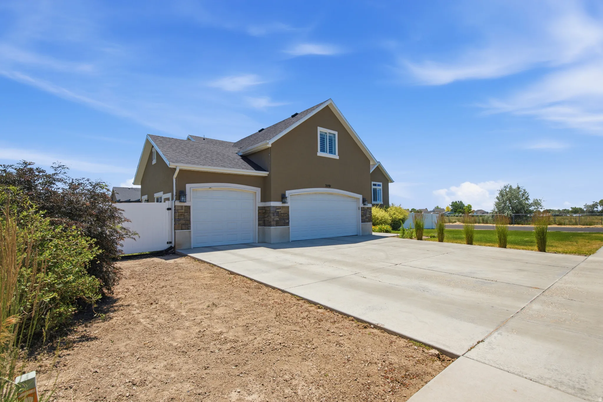 Two-car garage with arched white doors, complemented by a wide concrete driveway