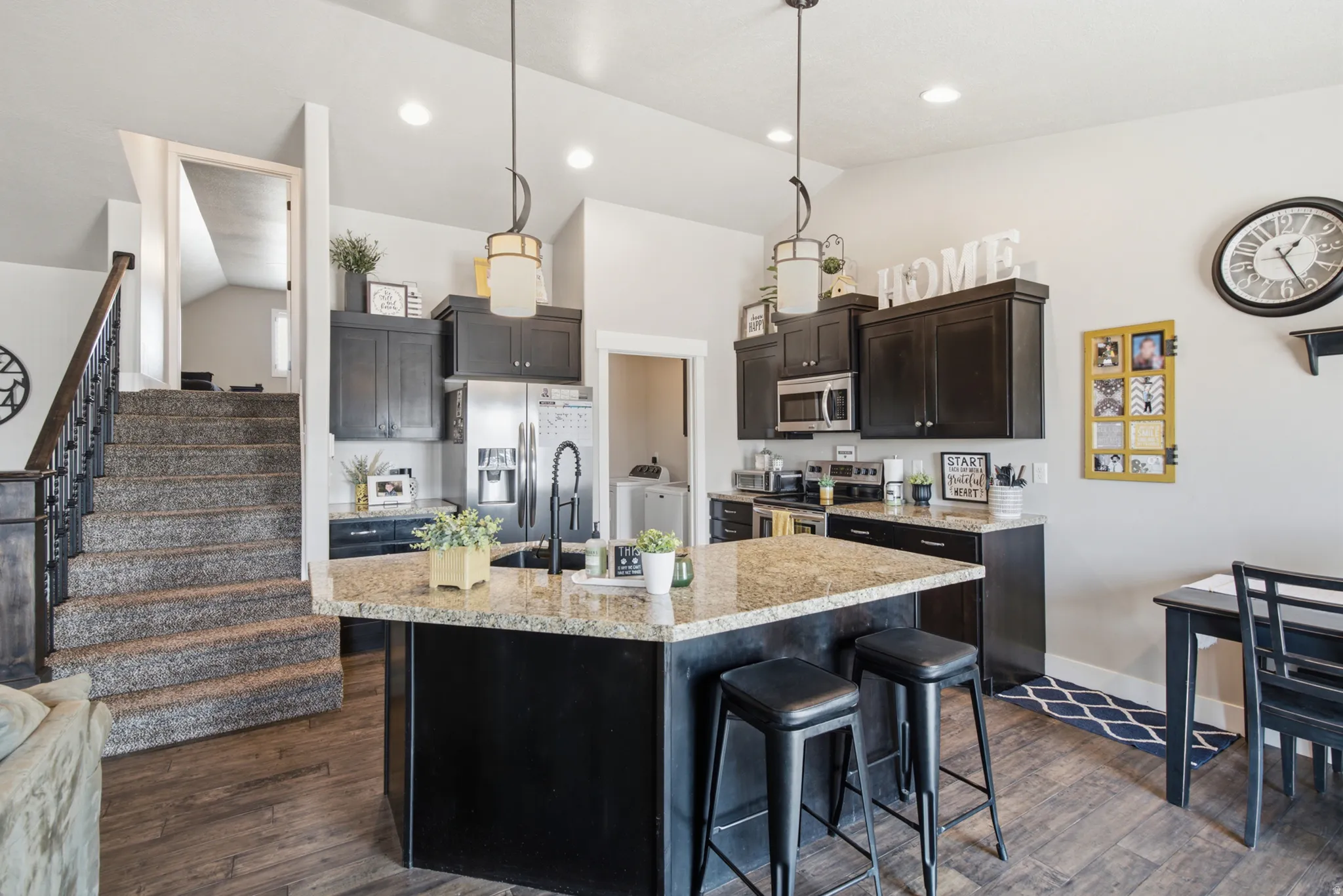Kitchen featuring dark cabinetry, stainless steel appliances, and a central island with a light-toned countertop