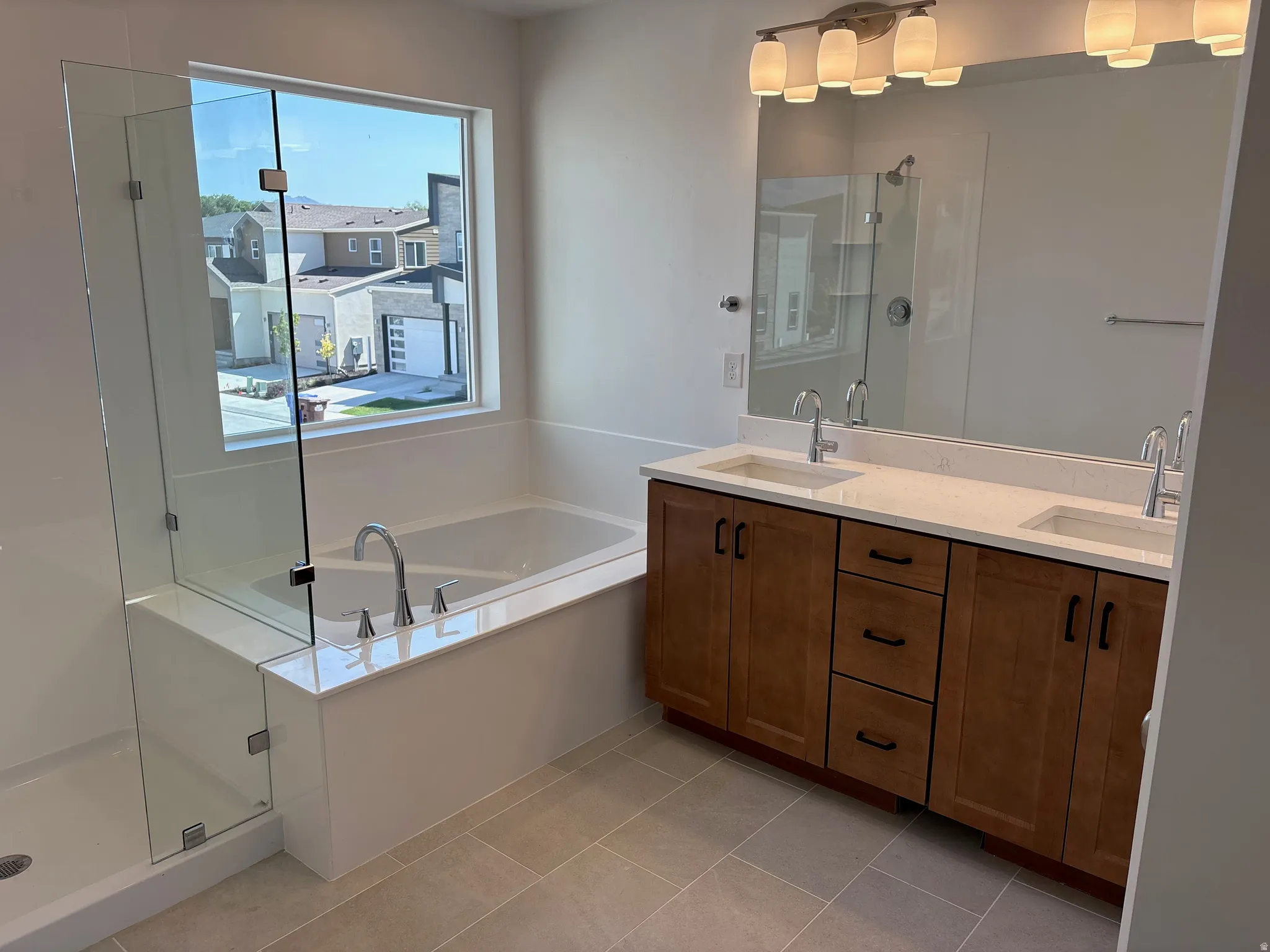 Contemporary bathroom featuring a built-in soaking tub, a separate glass-enclosed shower, and a dual vanity with a light-toned countertop