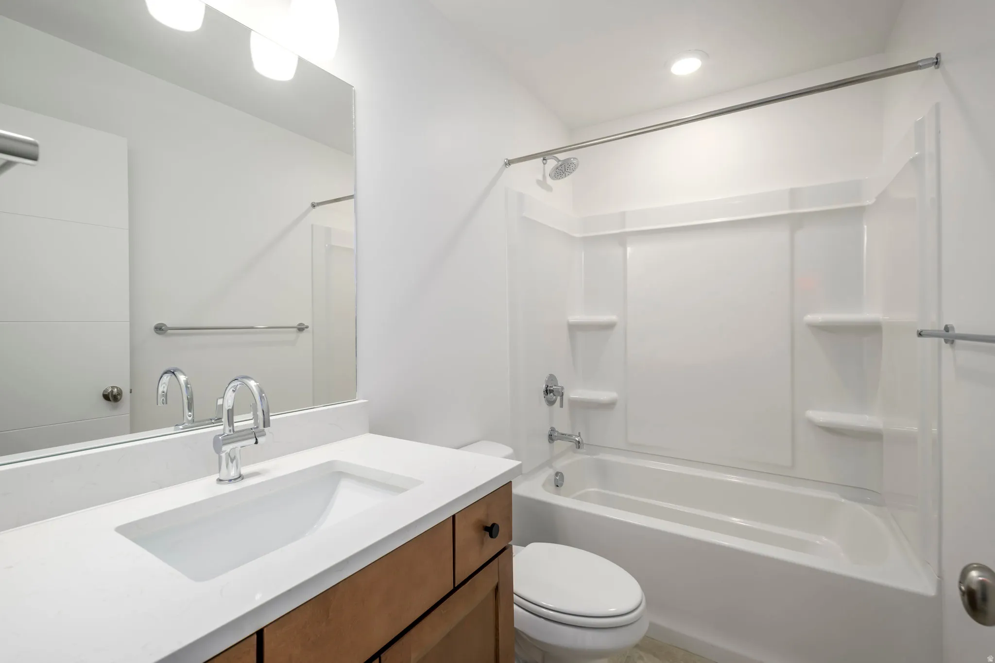 Bathroom featuring a full vanity with wood-finish cabinetry, a white countertop, and an integrated sink