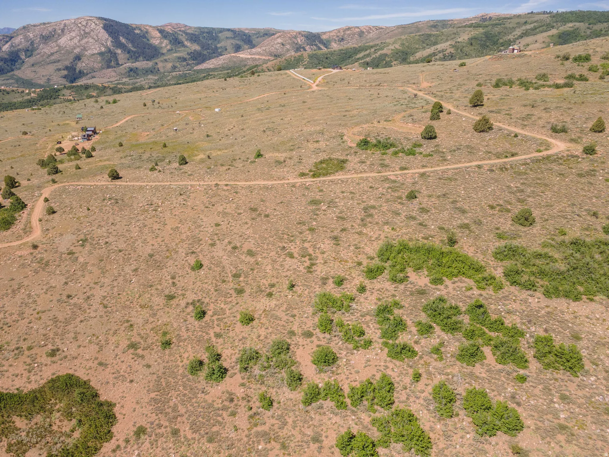 Expansive undeveloped acreage featuring multiple dirt roads and distant mountainous terrain