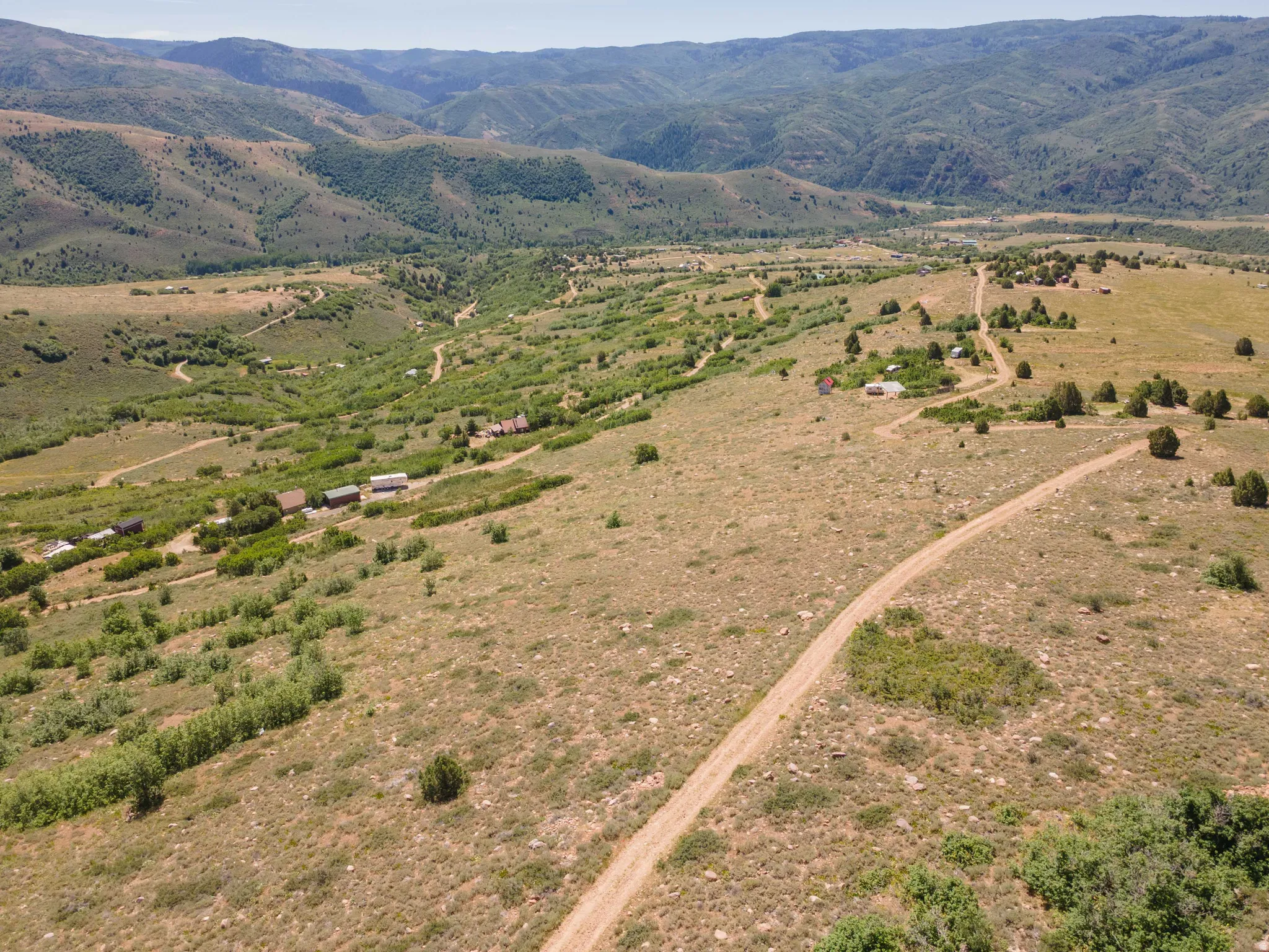Expansive rural landscape featuring rolling hills and distant mountains