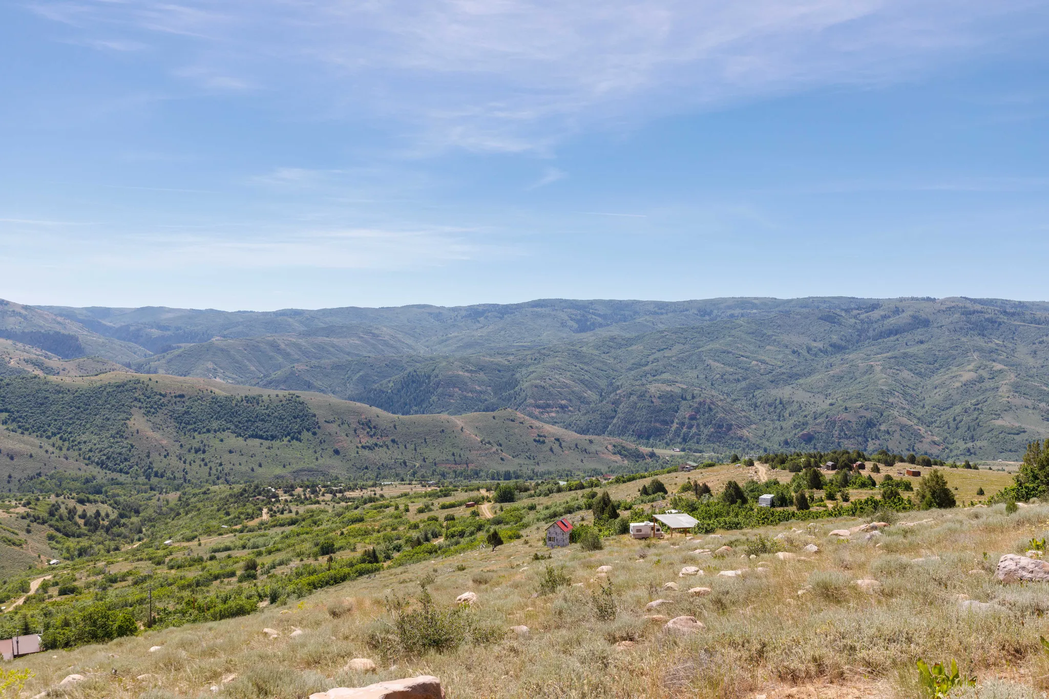 Expansive mountain landscape featuring rolling hills and abundant greenery