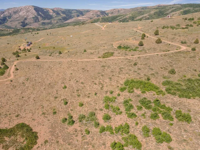 Expansive undeveloped acreage featuring multiple dirt roads and distant mountainous terrain