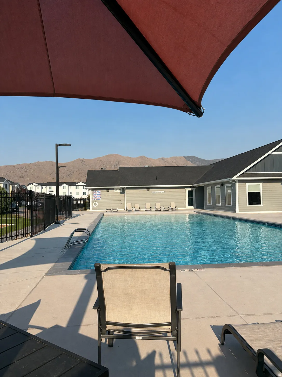 Expansive outdoor swimming pool with surrounding concrete decking