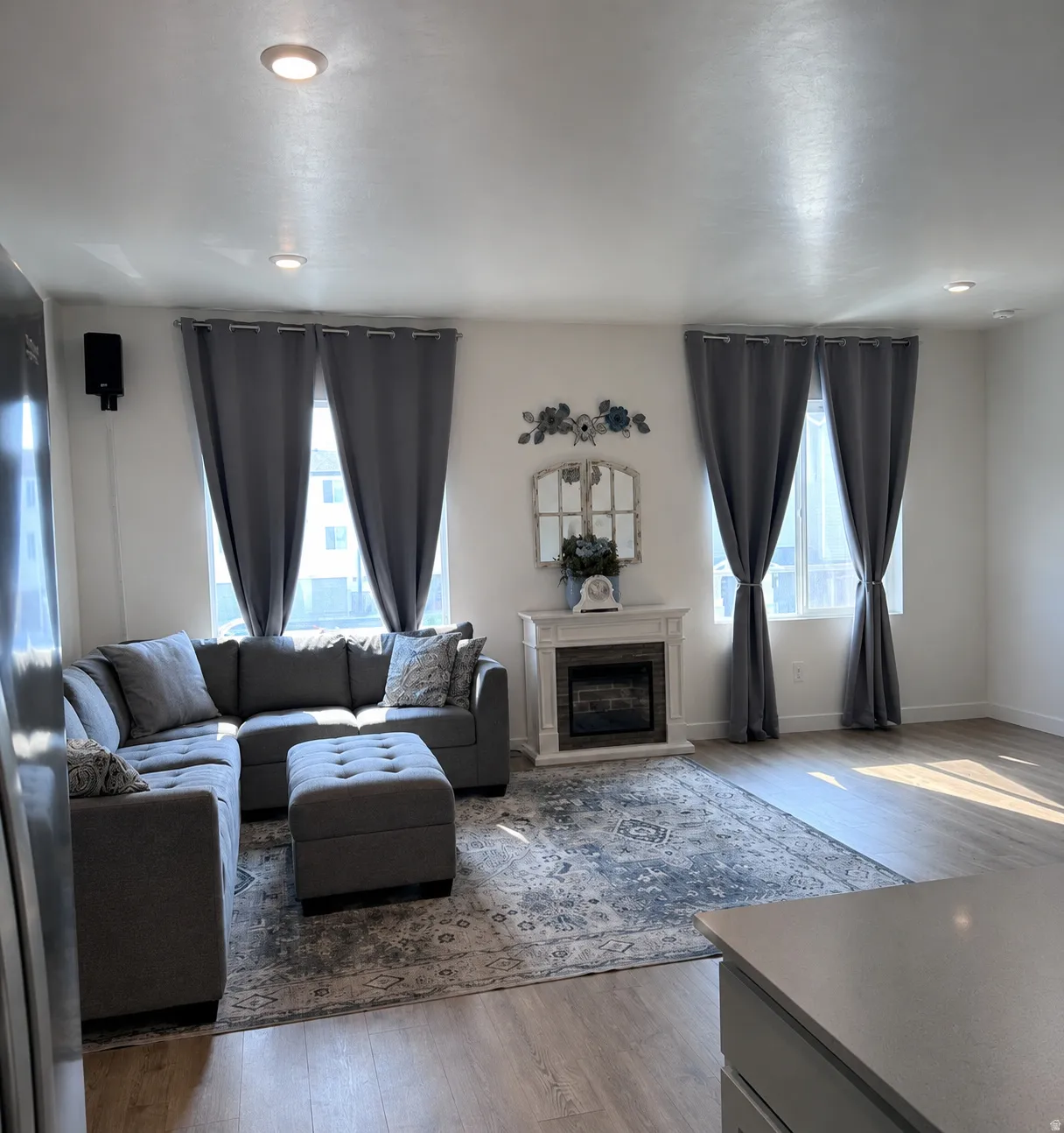 Living area featuring light wood-finish flooring, recessed ceiling lighting, and multiple windows