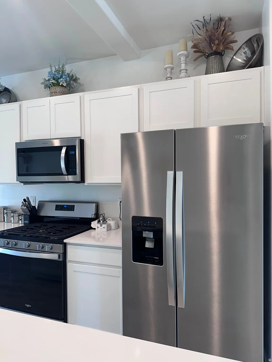 Kitchen featuring white shaker cabinetry, stainless steel appliances, white countertops, a gas range, and an over-the-range microwave