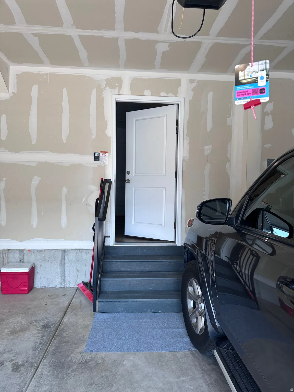 Garage space featuring an interior access door, concrete flooring, and unfinished drywall walls