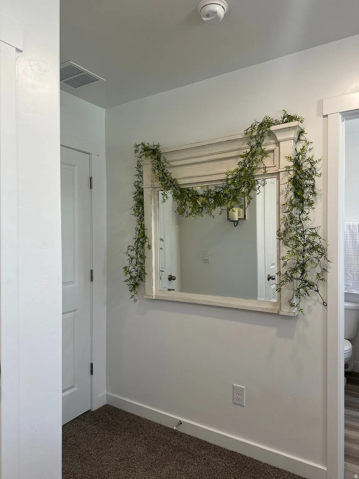 Full-length framed mirror with an ornate top molding