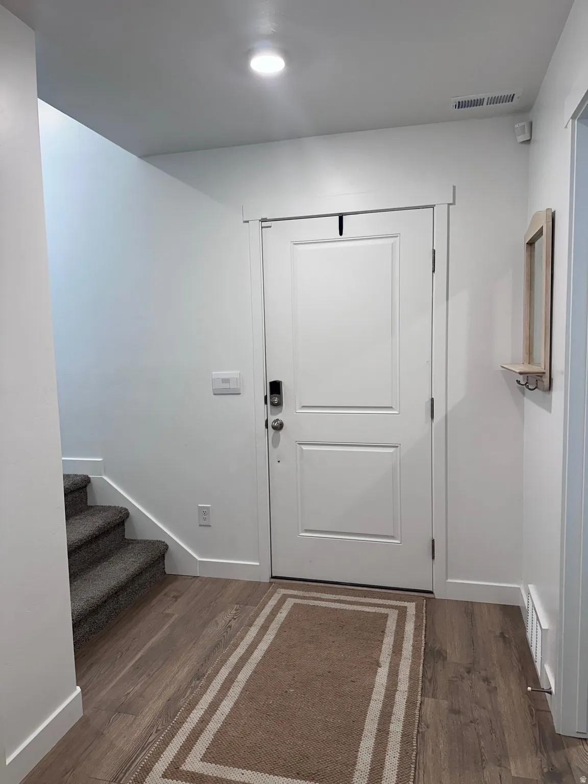 White paneled entry door with smart lock hardware