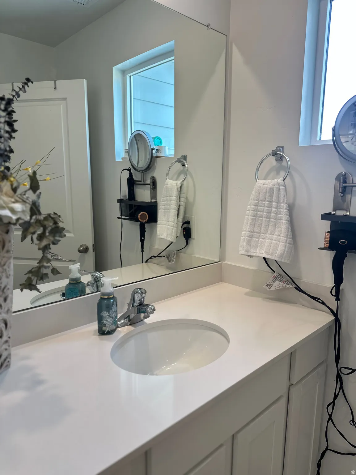 Bathroom vanity featuring a white countertop, an undermount sink, and a chrome faucet