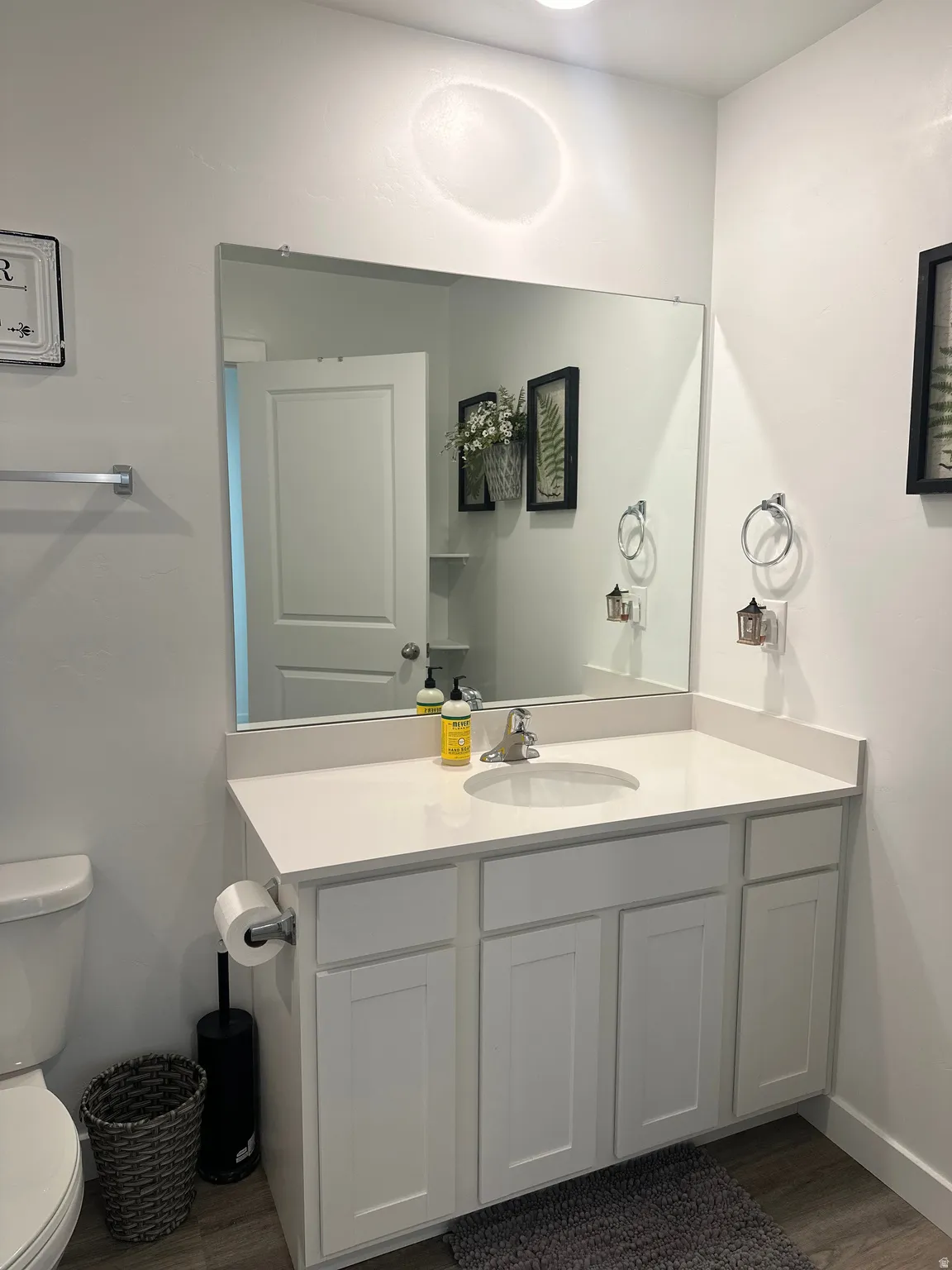 White shaker-style vanity featuring a solid surface countertop with an integrated sink and chrome faucet