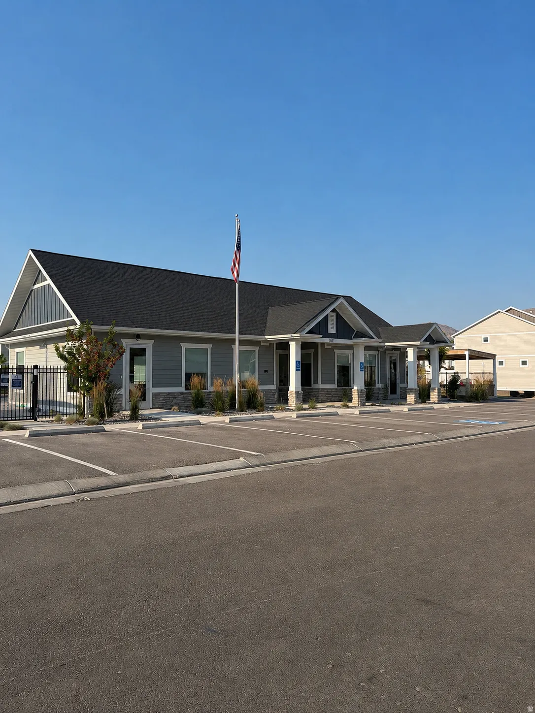 Modern commercial building featuring a gray siding exterior, stone accents, and multiple entryways