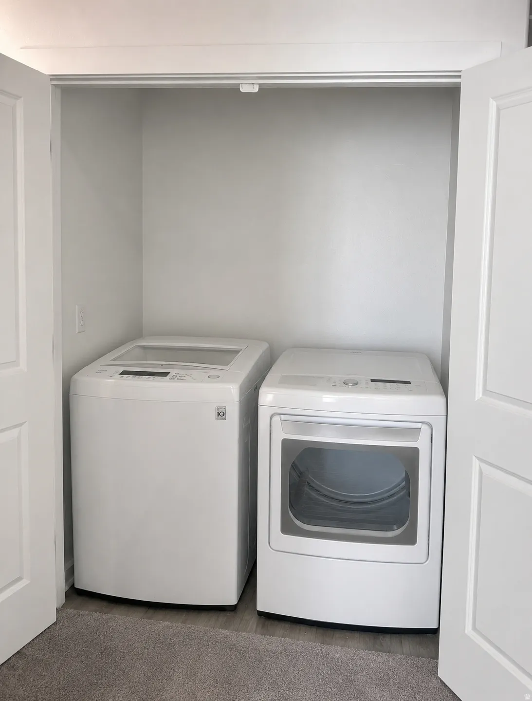 Dedicated laundry closet featuring a white top-load washer and a white front-load dryer