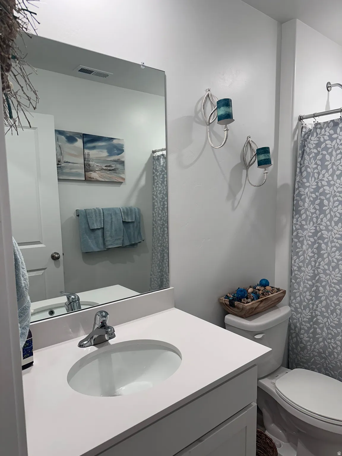 Bathroom featuring a white vanity with an integrated sink, polished chrome faucet, and a large wall-mounted mirror