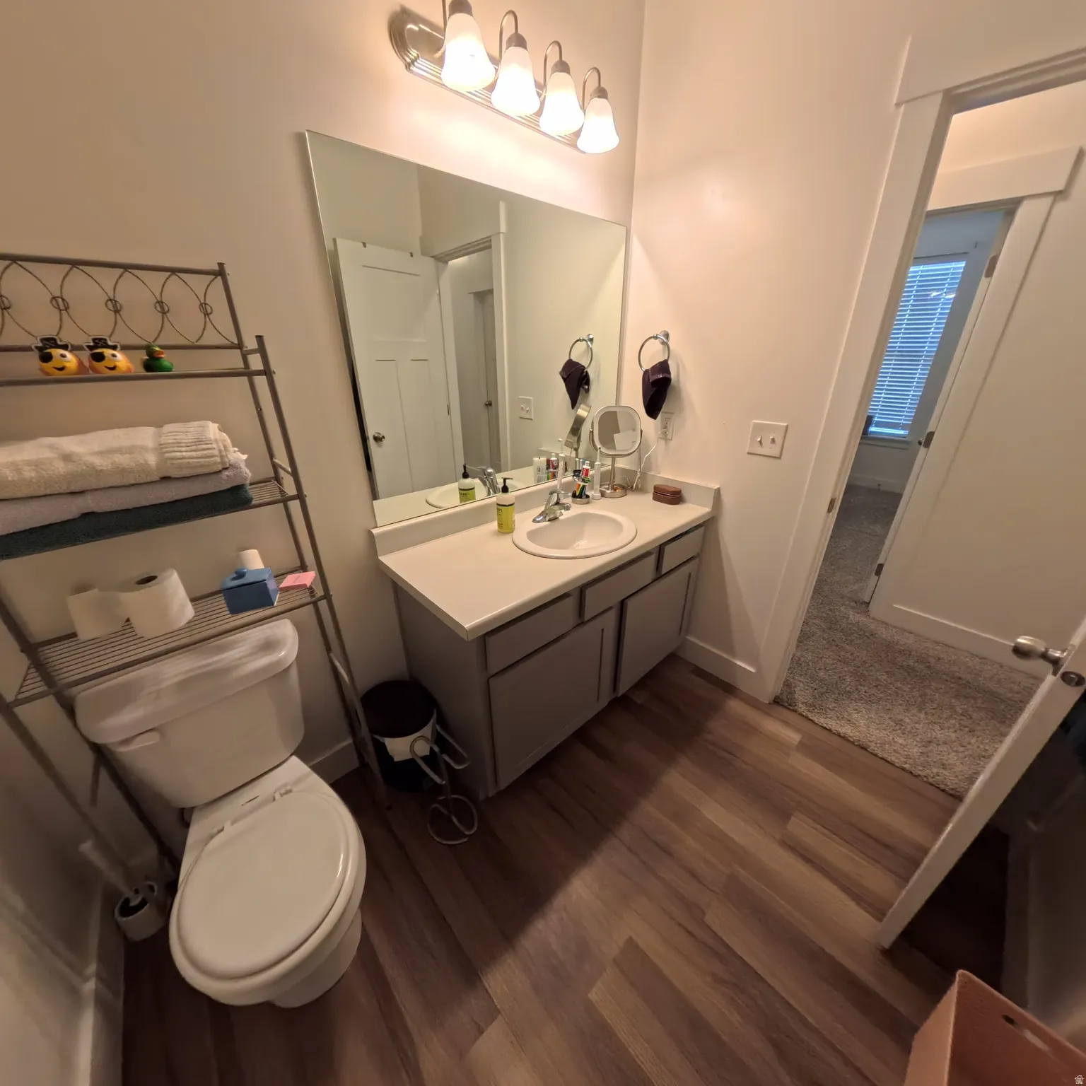 Bathroom featuring a single vanity with a white countertop, undermount sink, and modern faucet