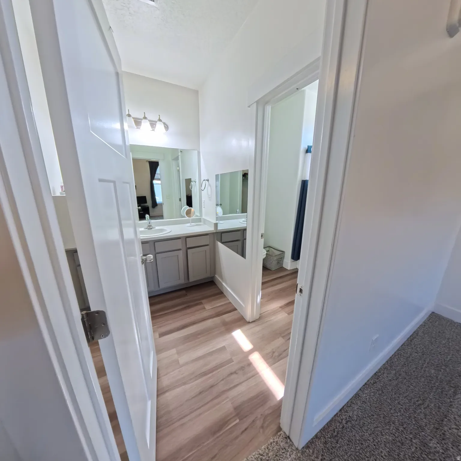Bathroom featuring a dual vanity with light grey cabinetry and a single basin sink