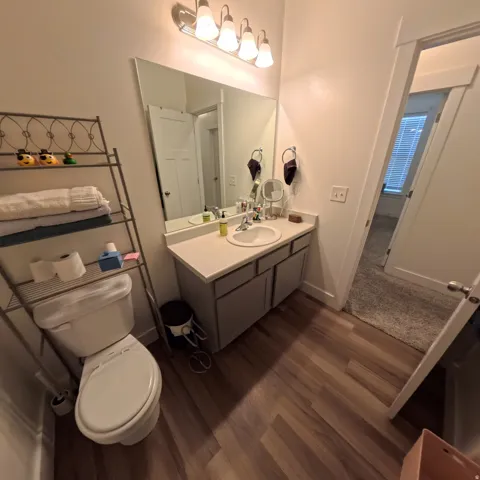 Bathroom featuring a single vanity with a white countertop, undermount sink, and modern faucet
