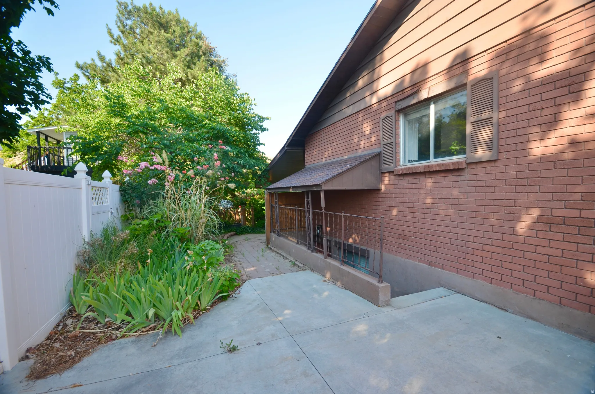 Brick exterior with wood siding, featuring a covered porch with metal railings