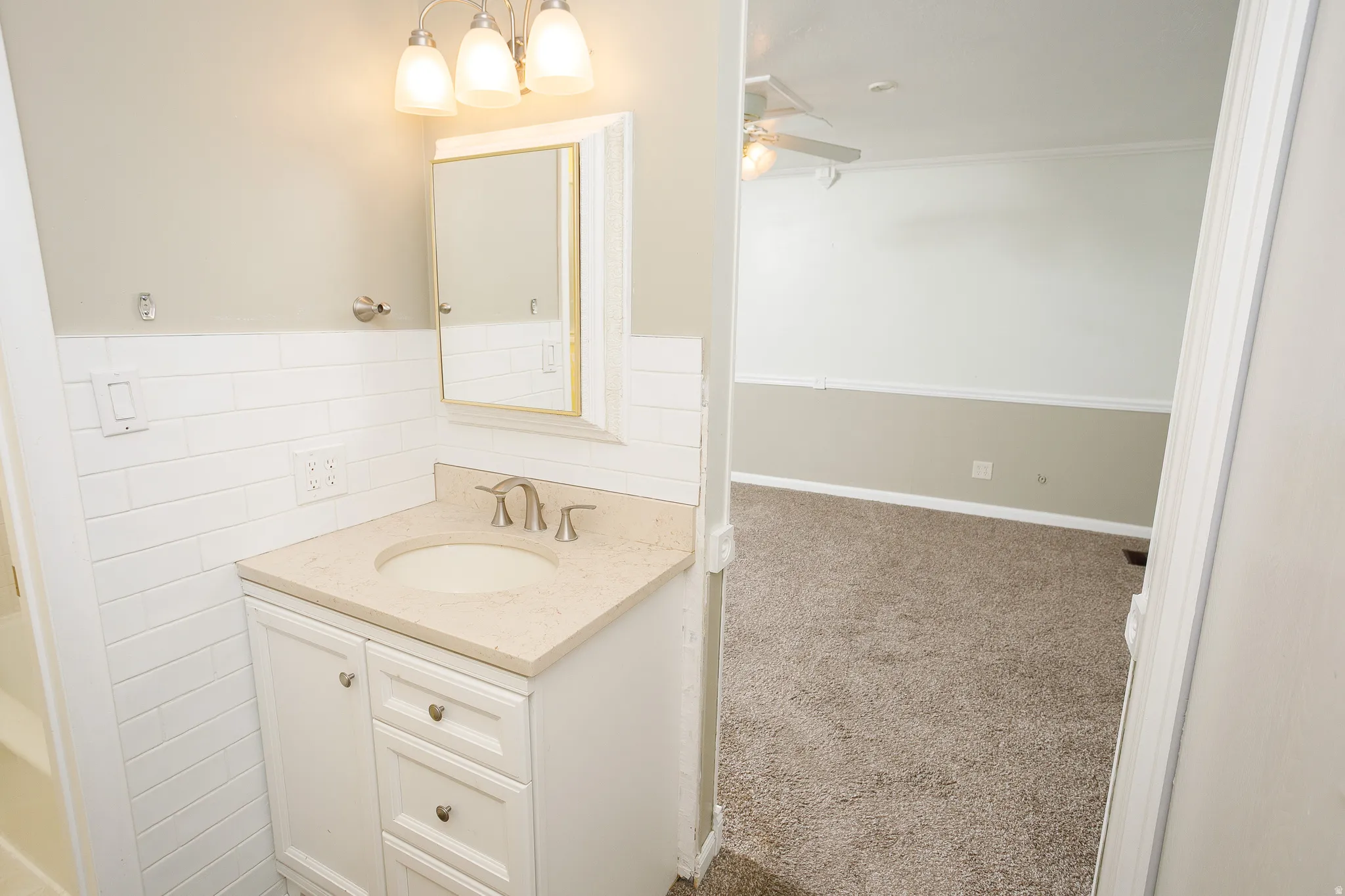 Bathroom vanity featuring white cabinetry, a built-in sink, and a light-toned countertop