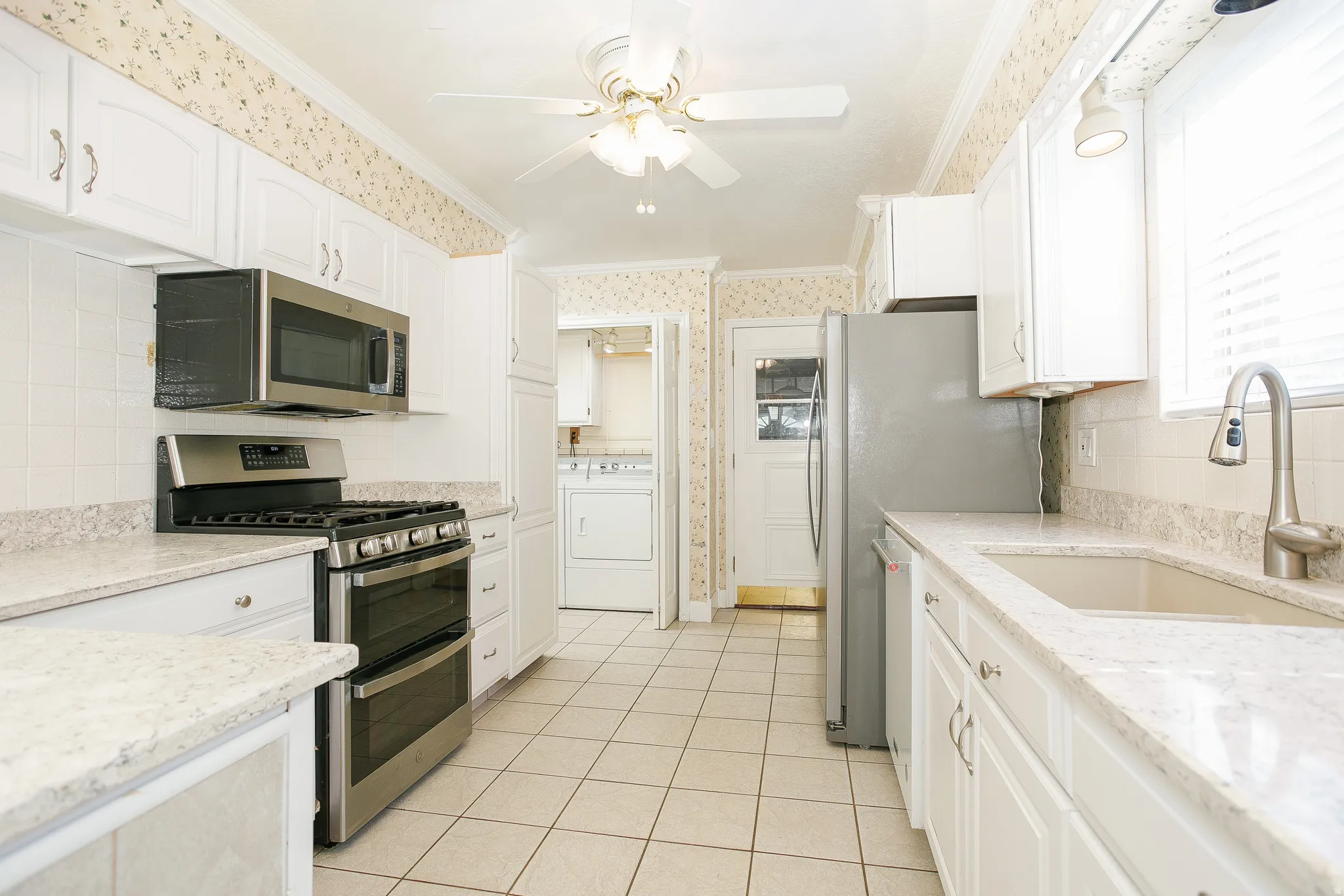 Kitchen featuring white cabinetry, light-toned countertops, and a tile backsplash