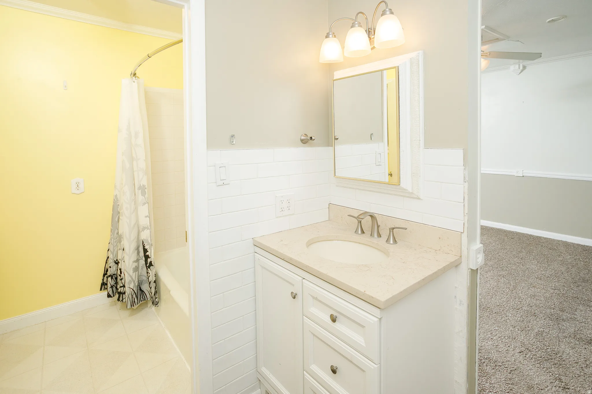 White vanity with integrated sink, light-colored countertop, and brushed nickel faucet