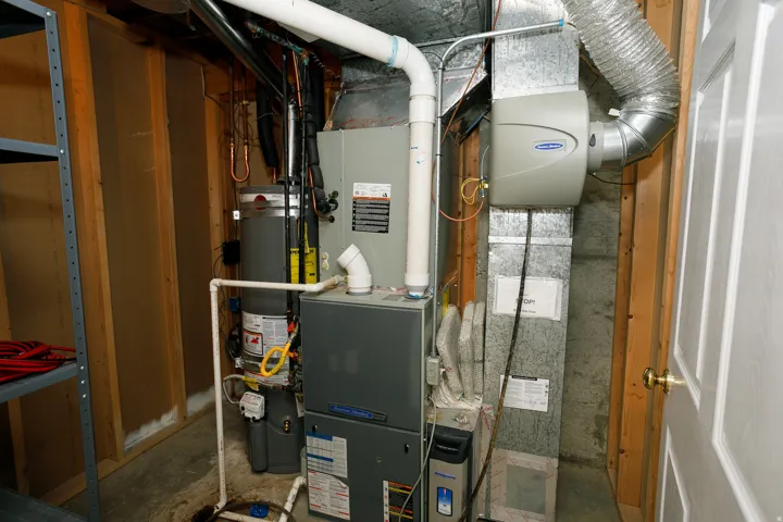 Utility area featuring a water heater, furnace, and whole-house humidifier