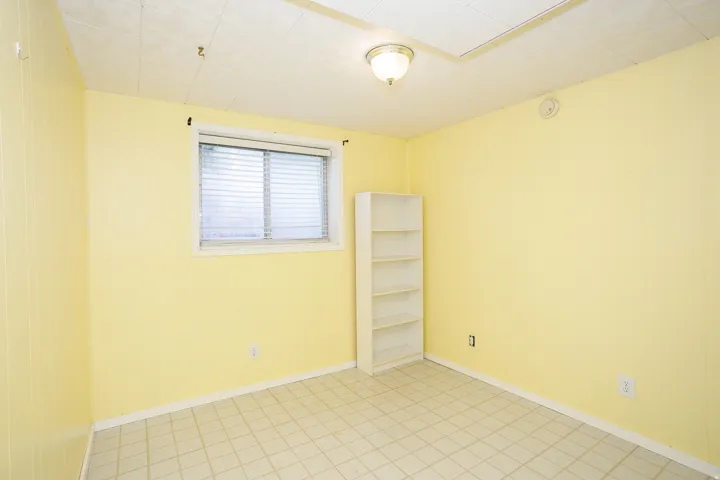 Room with light yellow walls and a window featuring horizontal blinds