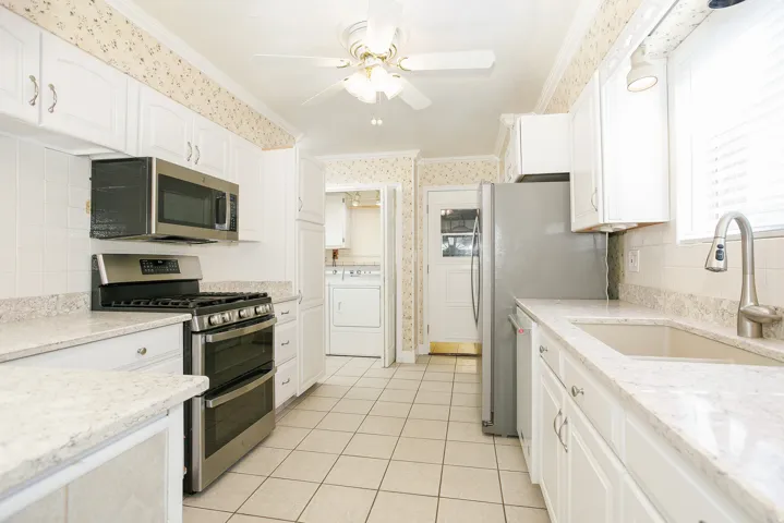 Kitchen featuring white cabinetry, light-toned countertops, and a tile backsplash