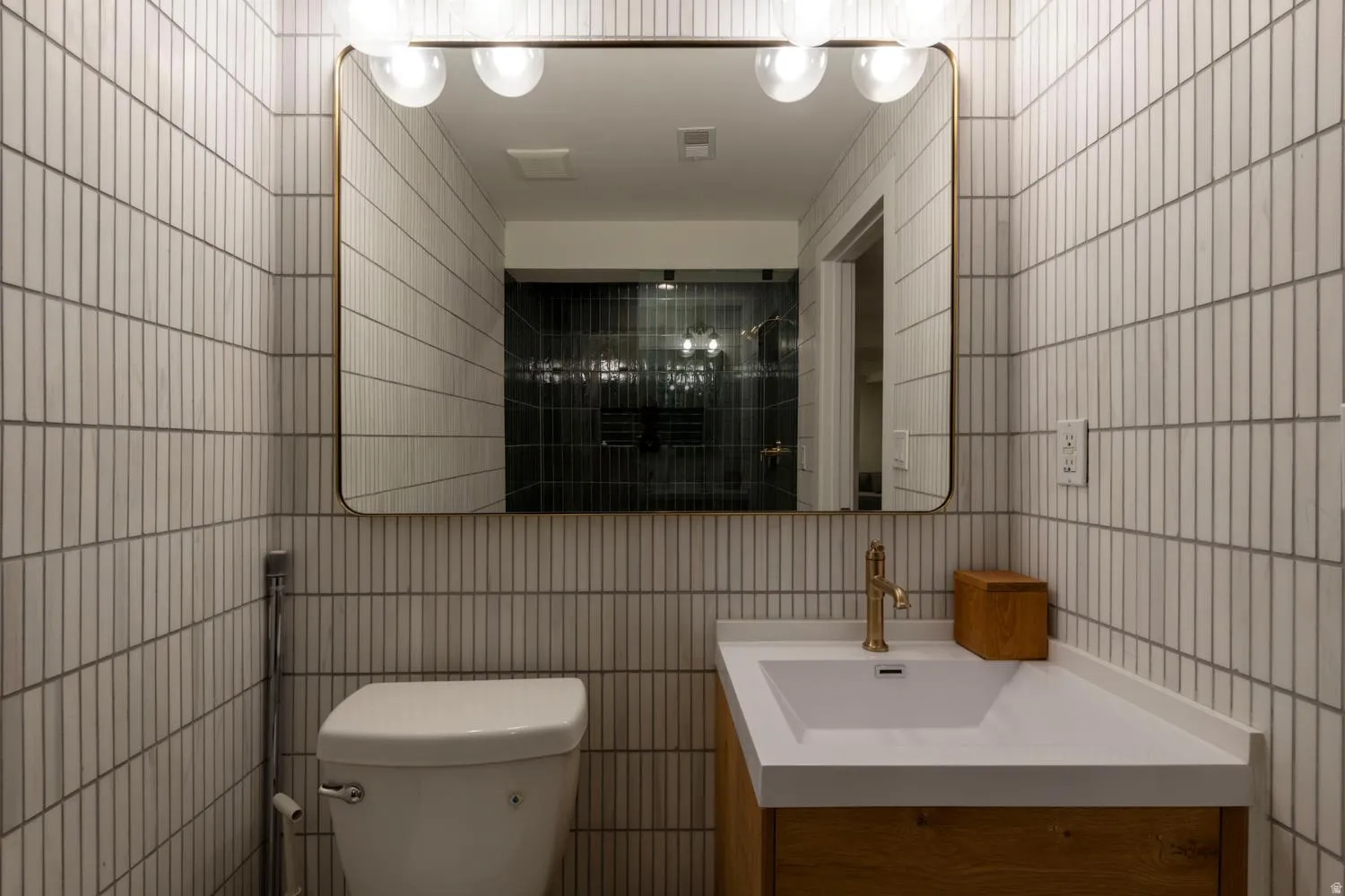 White vertical subway tile walls with a large rounded rectangular mirror