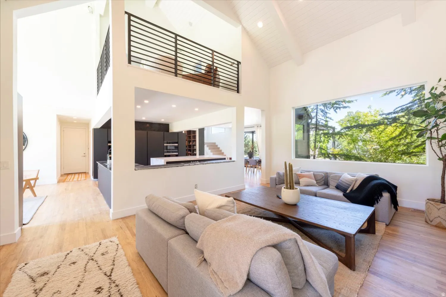 Vaulted ceilings and wood-finish flooring define this expansive living space with beautiful picture window