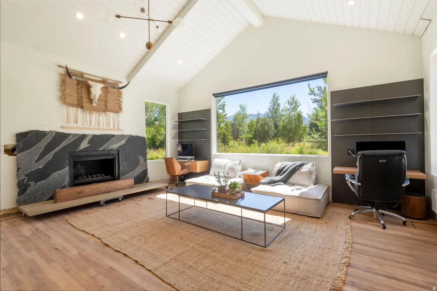 Vaulted white plank ceiling over wood-finish flooring, warm fireplace in office/den off primary suite. Beautiful picture window looking out on front yard Bull River and mountains to the East