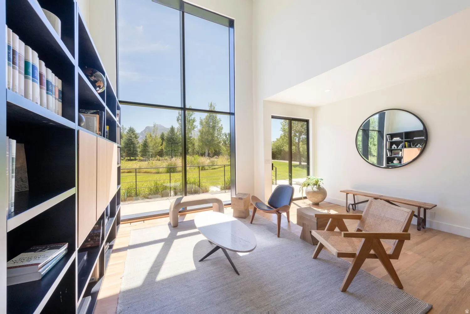 Double-height picture windows with black frames, plenty of light in this lovely living room area