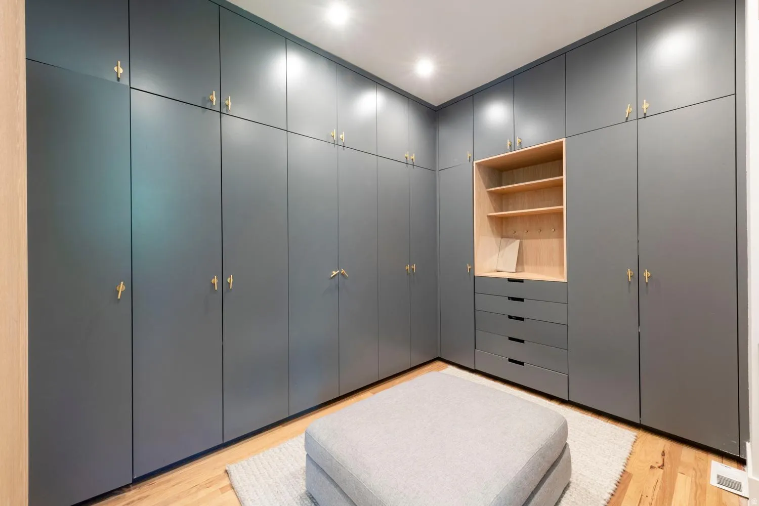Custom built-in cabinetry featuring matte gray panels and brass hardware