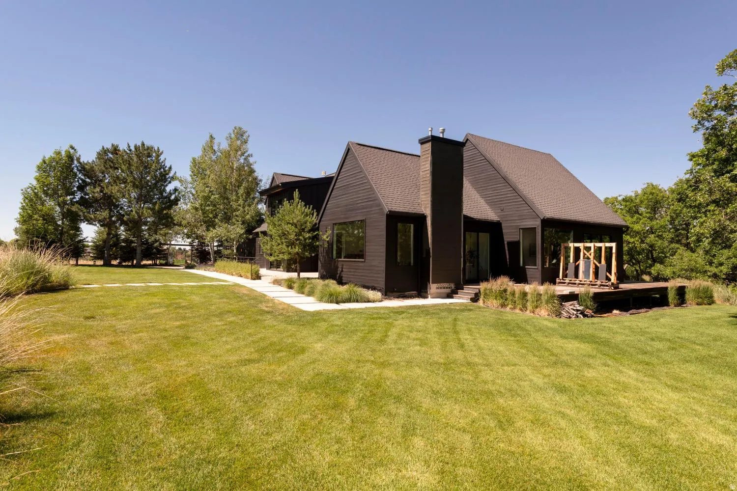 Modern dark-clad exterior featuring a prominent chimney structure and multiple windows