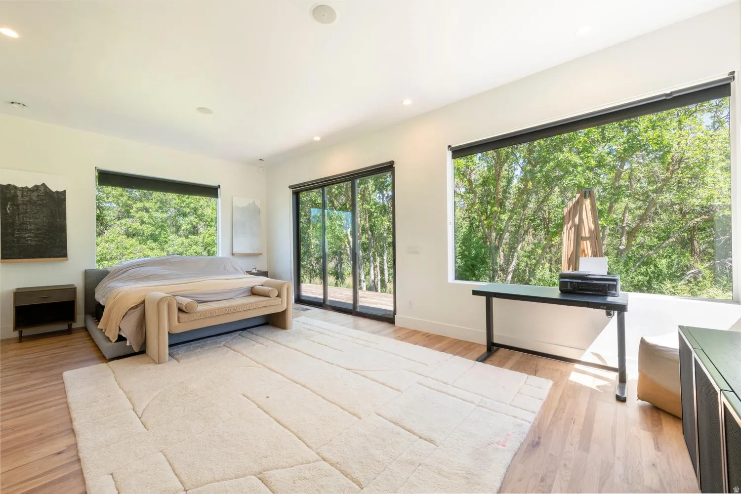 Bright interior with wood-finish flooring, recessed lighting, expansive windows, and a sliding glass door providing access to lovely deck