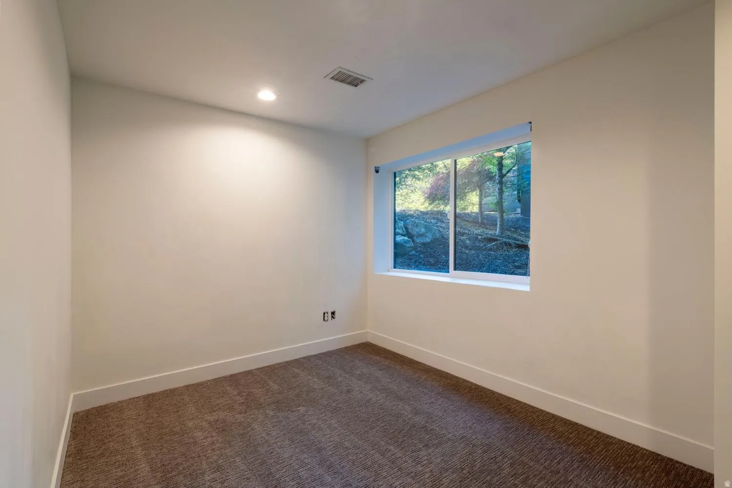 Window with natural light, recessed lighting, neutral wall tones, white trim, and carpeted flooring