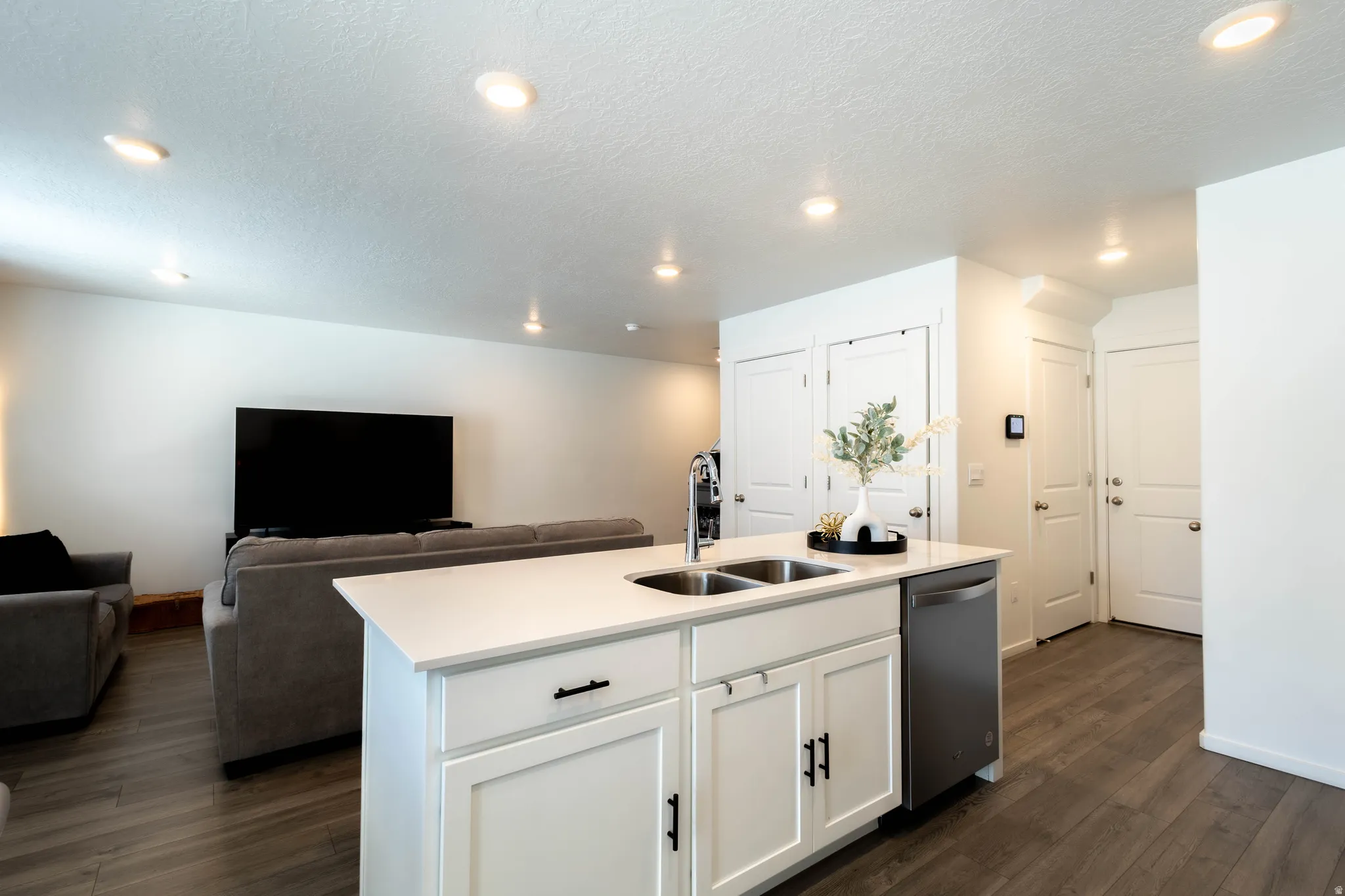 Kitchen island featuring a double-basin sink and stainless steel dishwasher