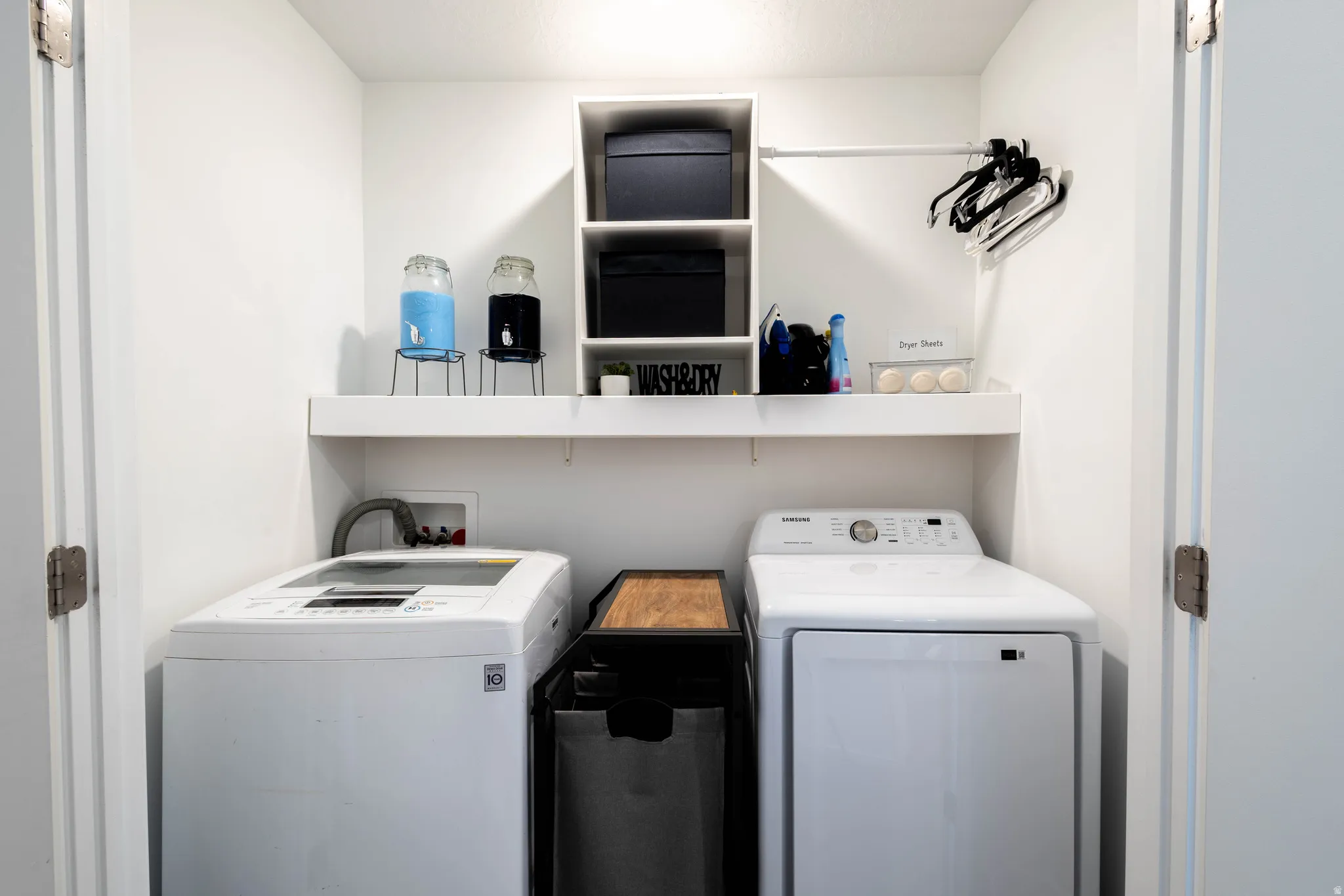 Dedicated laundry area featuring a white top-load washing machine and front-load dryer