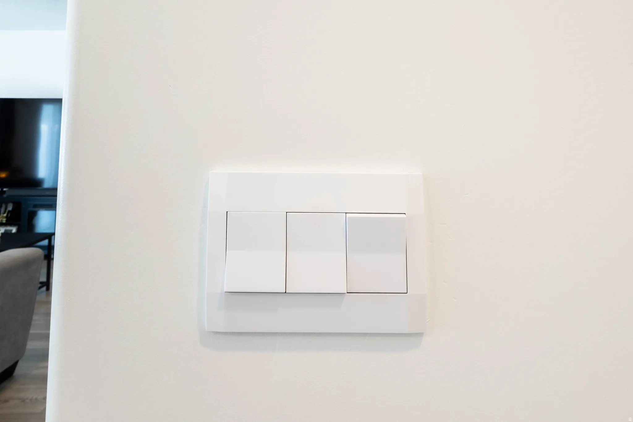 White triple-gang light switch plate on a neutral wall