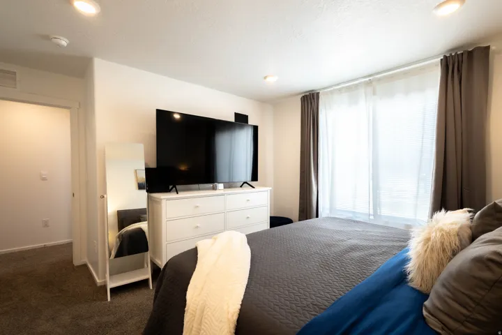Recessed lighting, carpeted flooring, and a large window with blinds and drapes